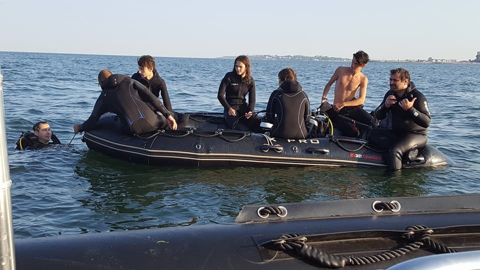 Barca mică folosită pentru scufundările de lângă mal, cu cursanți pregătindu-se de intrare